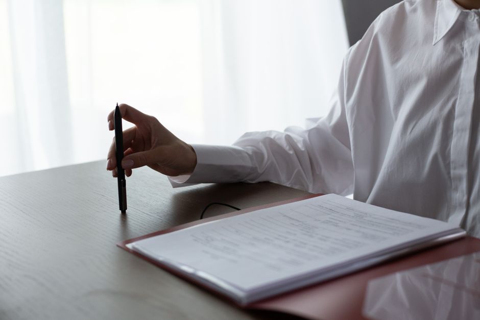 A person reviewing an application form at a desk with several documents spread out, showing focused attention to detail - free immigration lawyer help mcallen tx