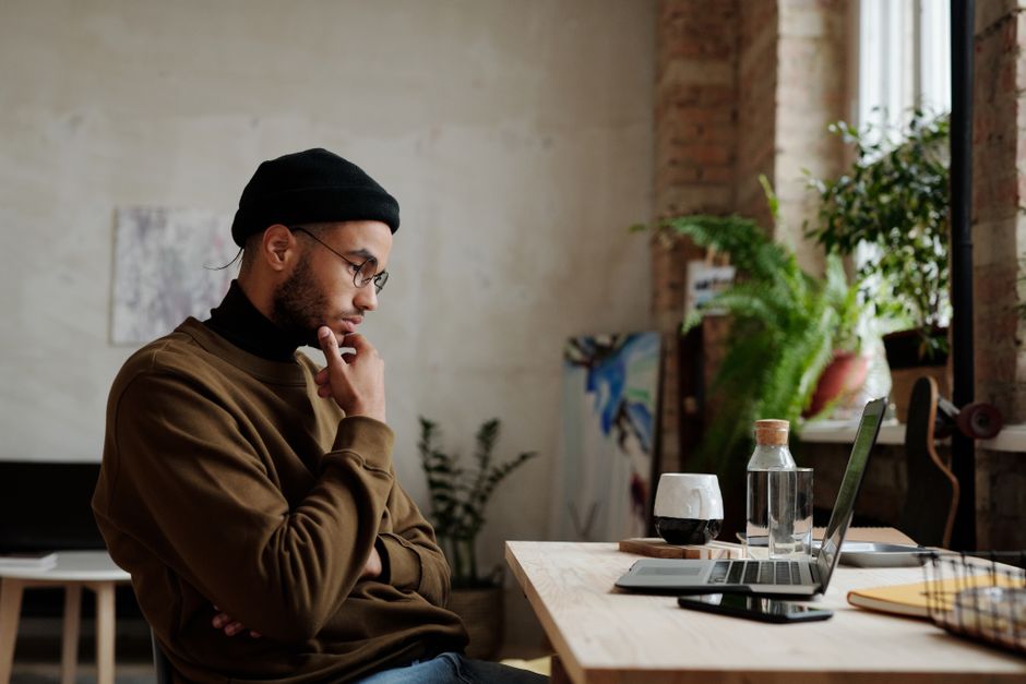 A person looking thoughtfully at a laptop screen, contemplating immigration options. - immigration lawyer for work visas