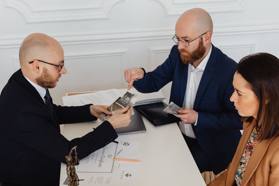 A lawyer consulting with a client over documents in an office setting, pointing to a document with a pen - visitor visa lawyer
